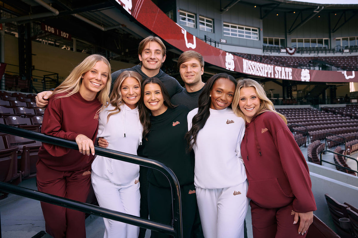 Group of people posing together in a stadium setting