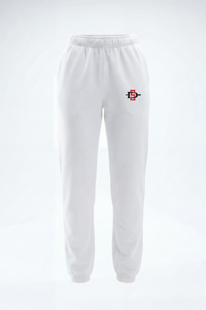White sweatpants with an elastic waistband and cuffs, featuring a small red and black embroidered logo on the left hip, shown against a plain white background.