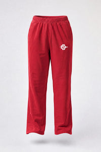 Red sweatpants with an elastic waistband and a small embroidered mascot logo on the left thigh, shown against a light gray background.