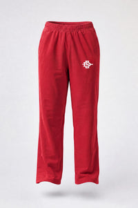 Red sweatpants with an elastic waistband and a small embroidered mascot logo on the left thigh, shown against a light gray background.