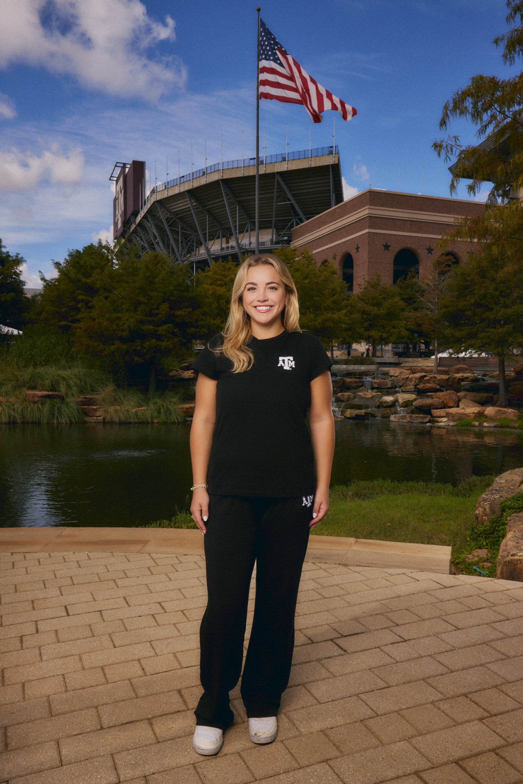 young woman wearing black texas A&M tee and sweatpants set from AVO