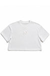 A white short-sleeve crop top t-shirt with a small, subtle metallic gold graphic on the center chest, displayed flat against a solid white background.