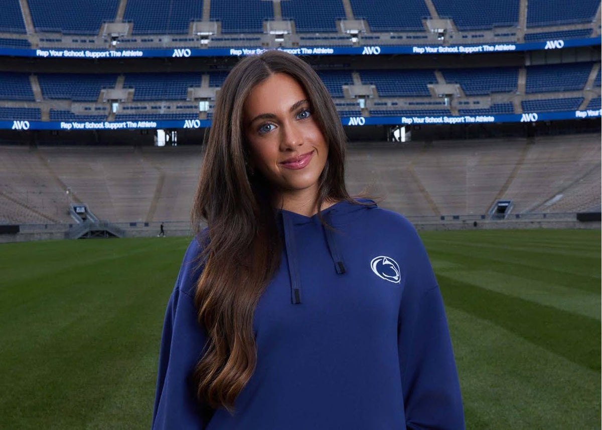 Model wearing the Penn State Logo Softest Fleece Hoodie in navy inside Beaver Stadium