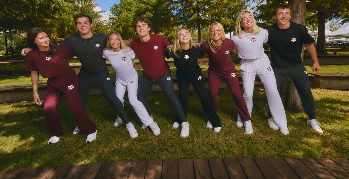 Eight students wearing maroon, black and white Texas A&M apparel on campus.